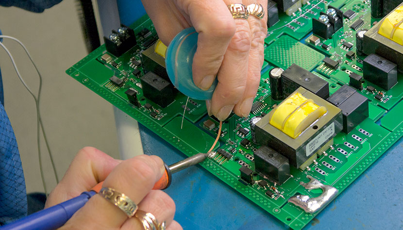 Worker soldering on a circuit board